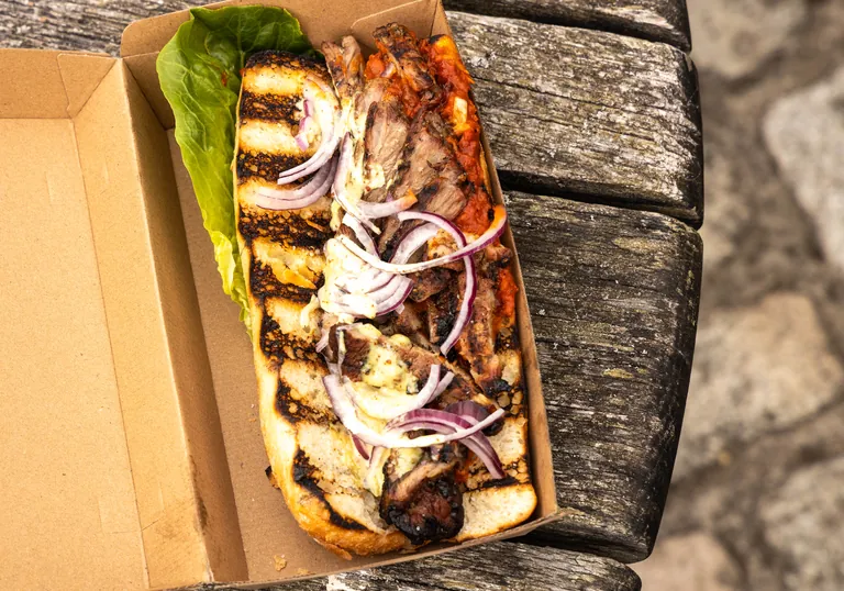 Loaded takeaway box of grilled meat and onions