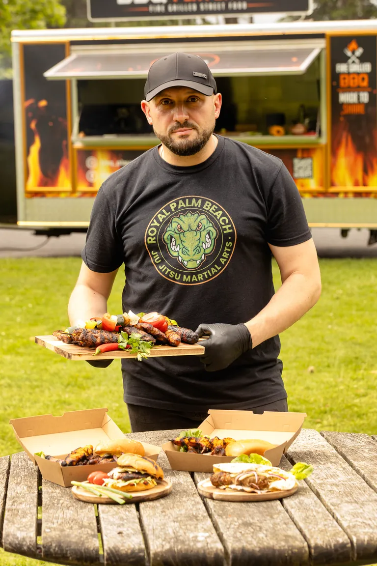 BBQ Playground owner serving food beside the catering trailer
